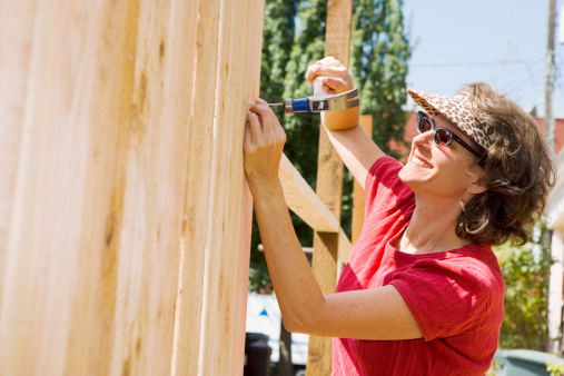 Smiling woman building fence